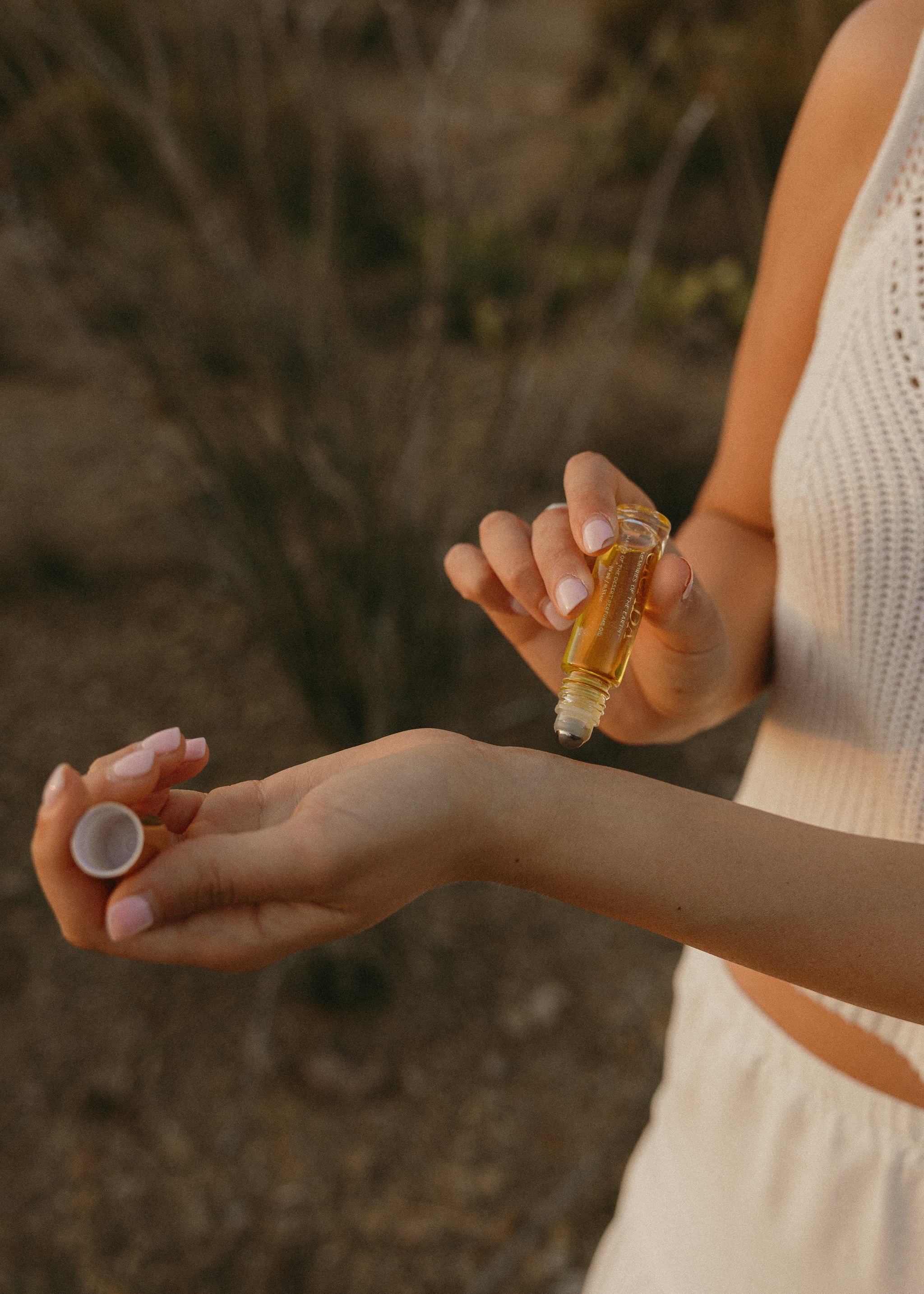 Lifestyle image of person applying roller ball to wrists. 