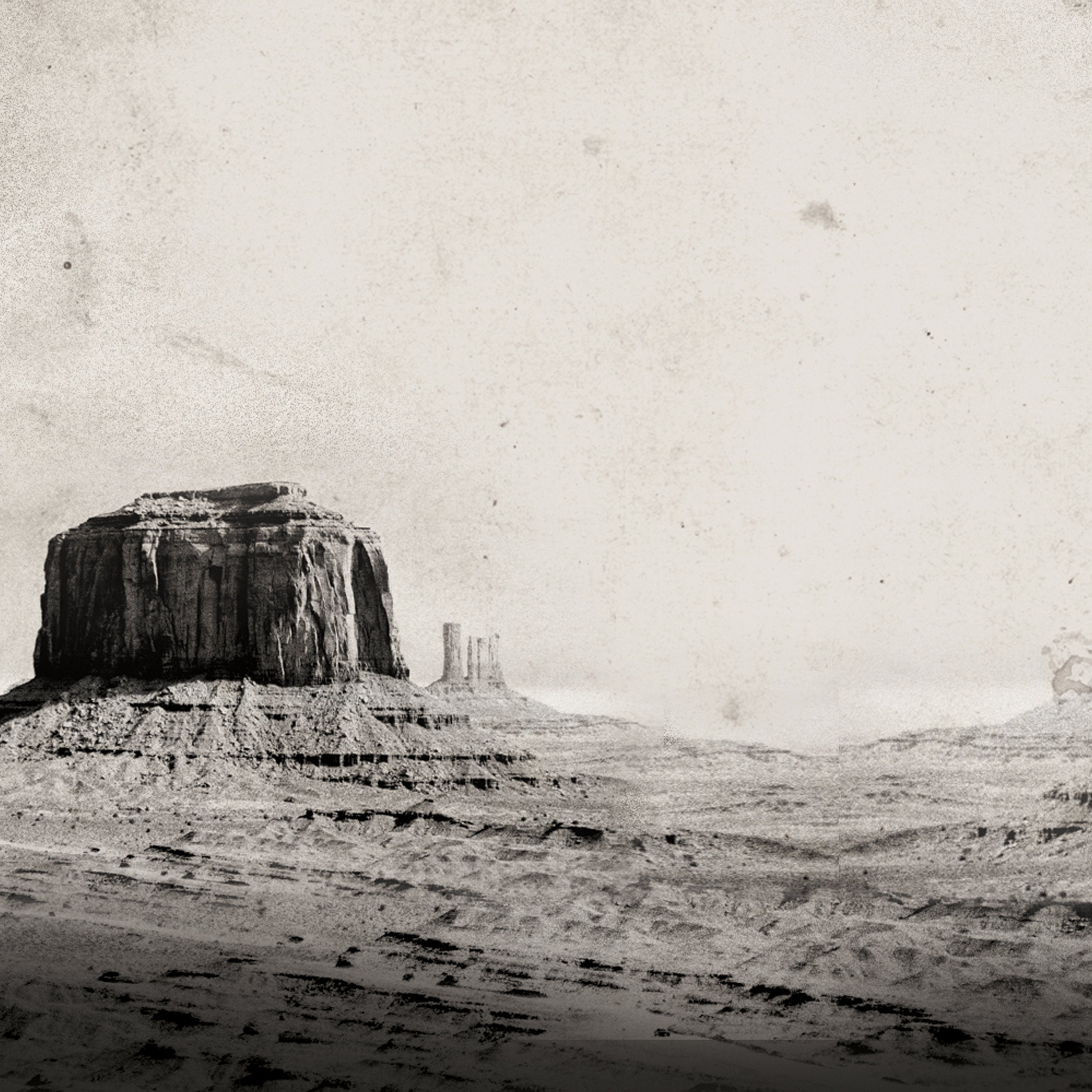 Vintage-style sepia-toned landscape photograph of a desert butte and rocky mesa formations under a pale sky, with a distressed, aged-paper texture.
