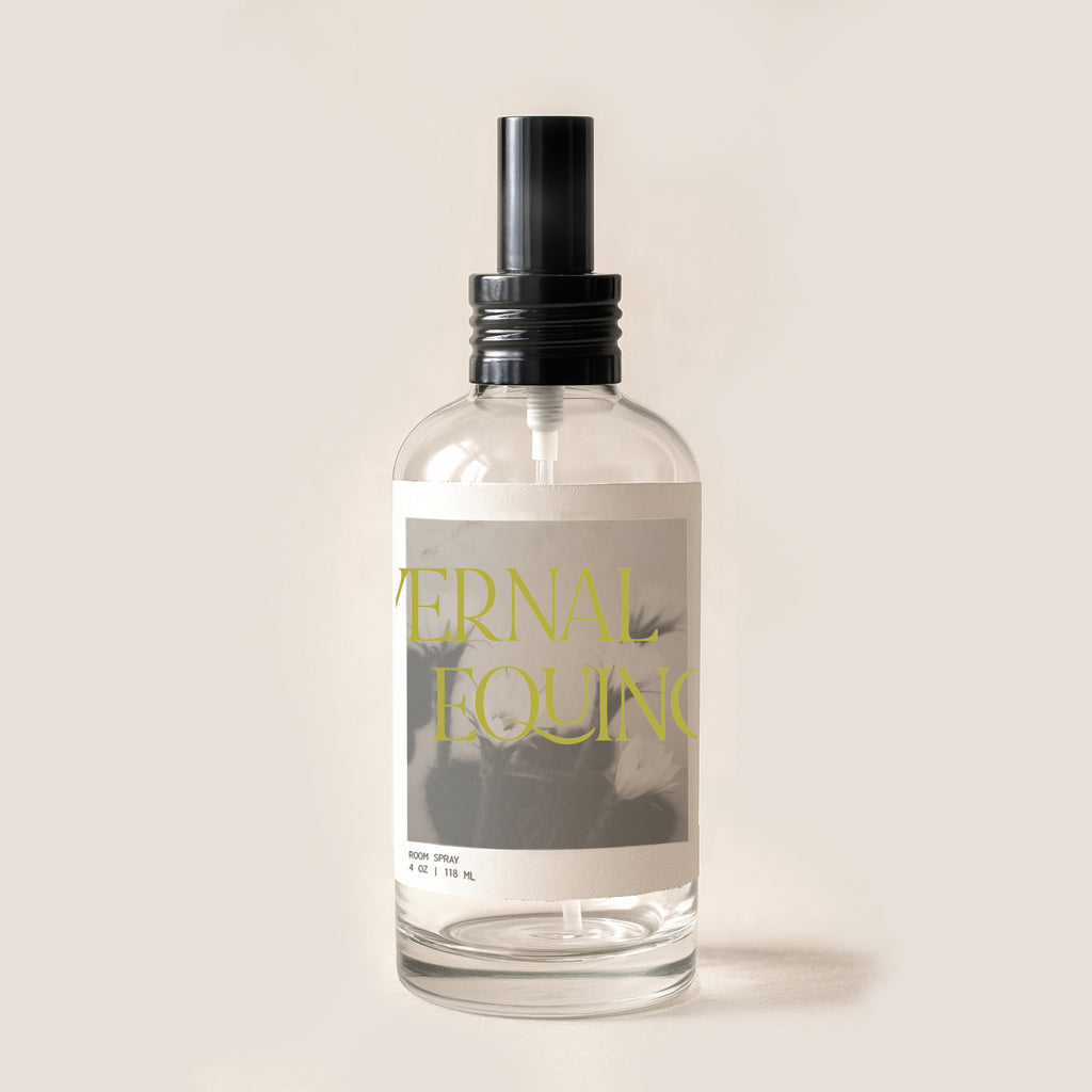 Clear spray bottle with black nozzle on a light beige background