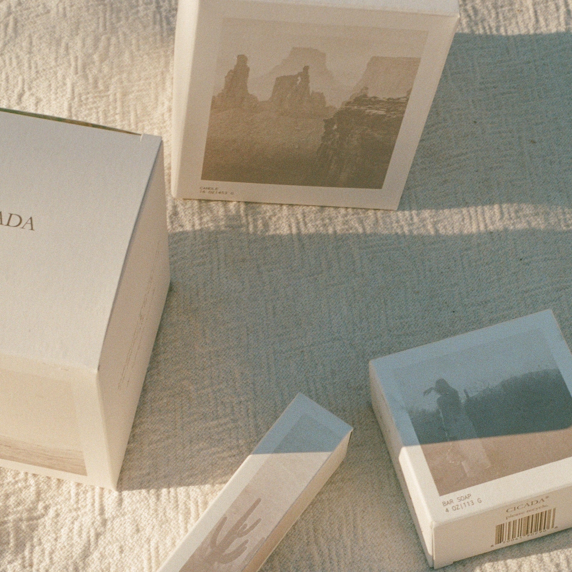 Small boxes with scenic images on a textured surface. 
